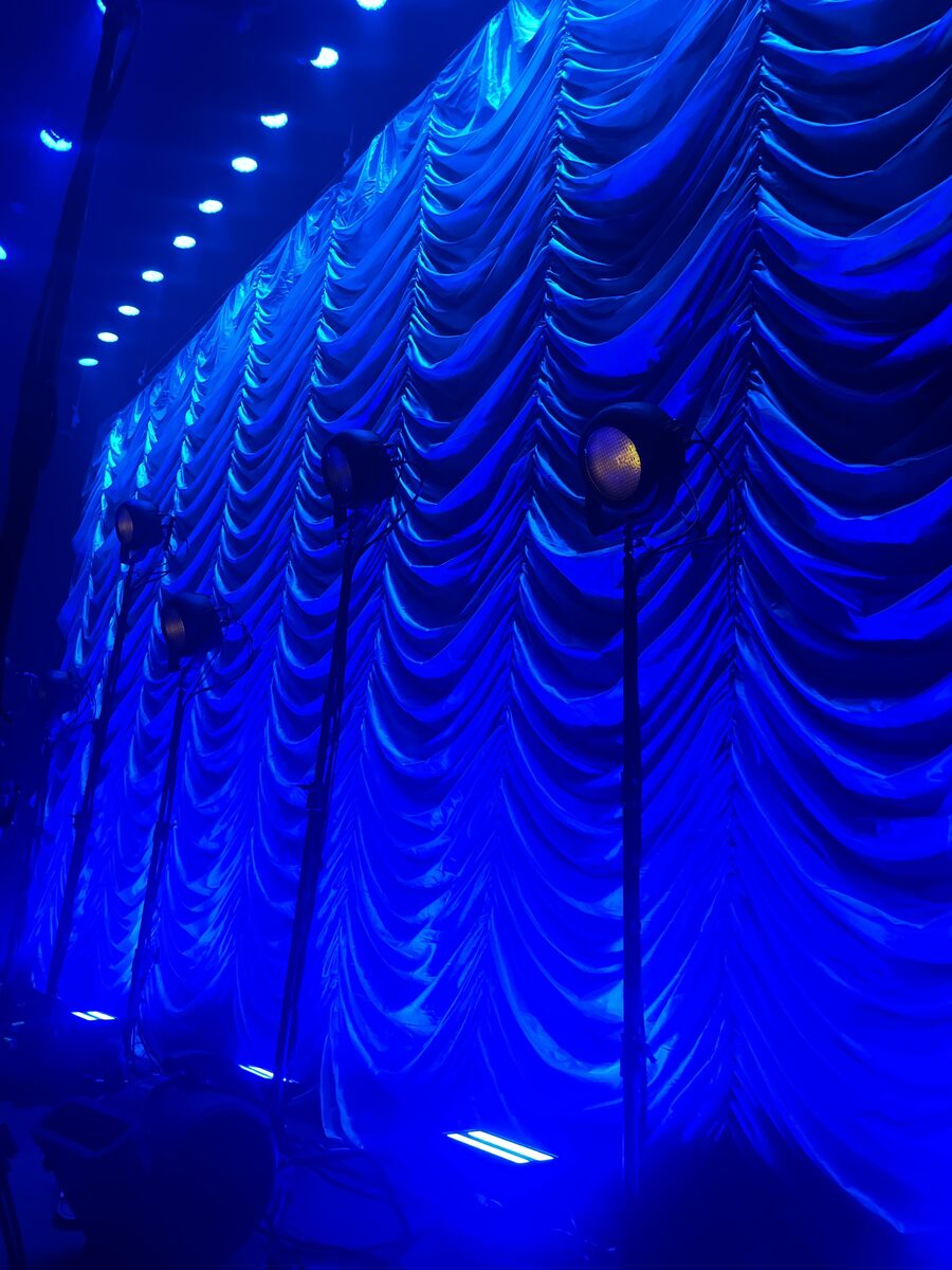 Silver Austrian swoop drape wall with blue lighting