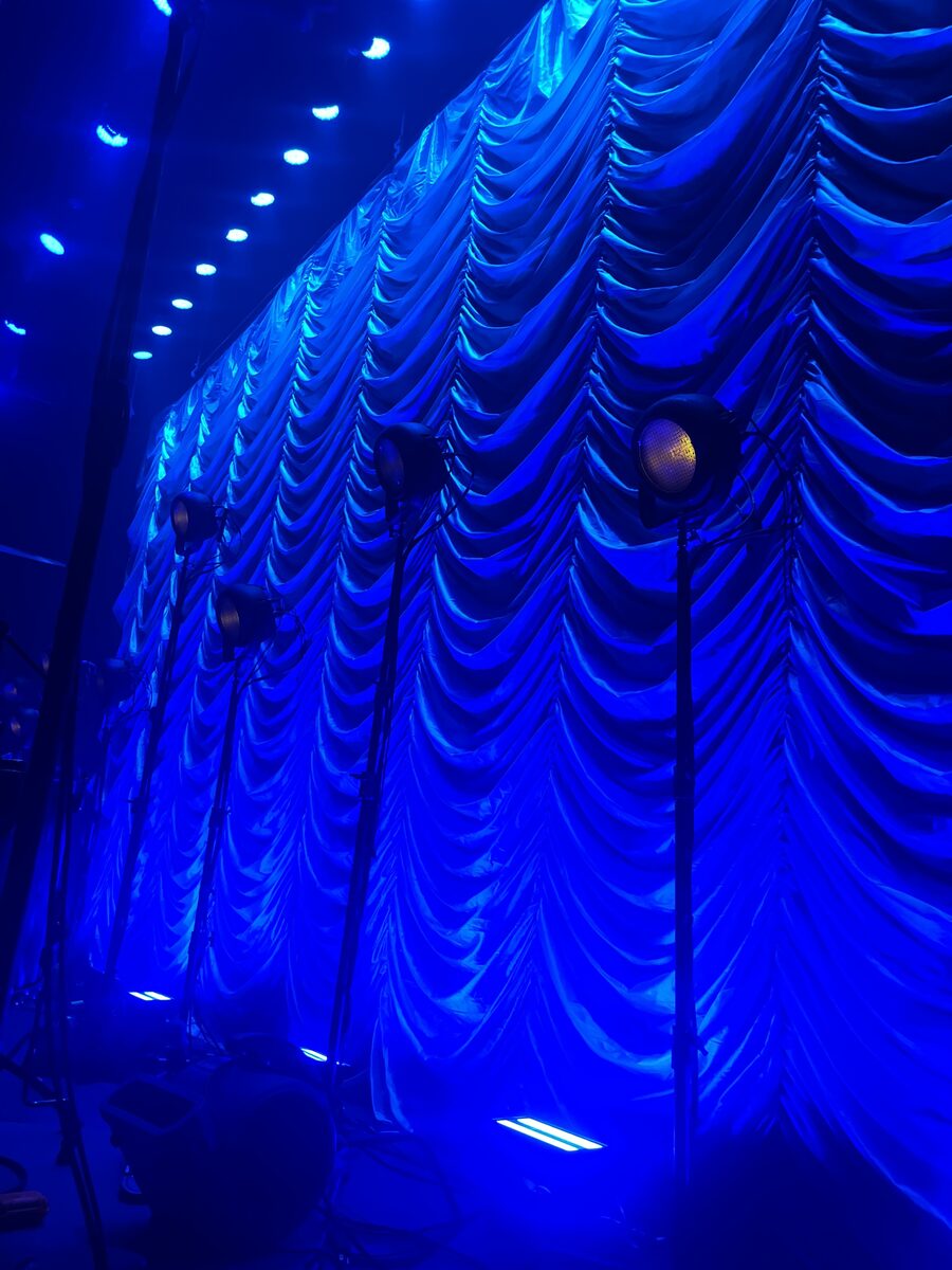 Silver Austrian swoop drape close-up with blue lighting