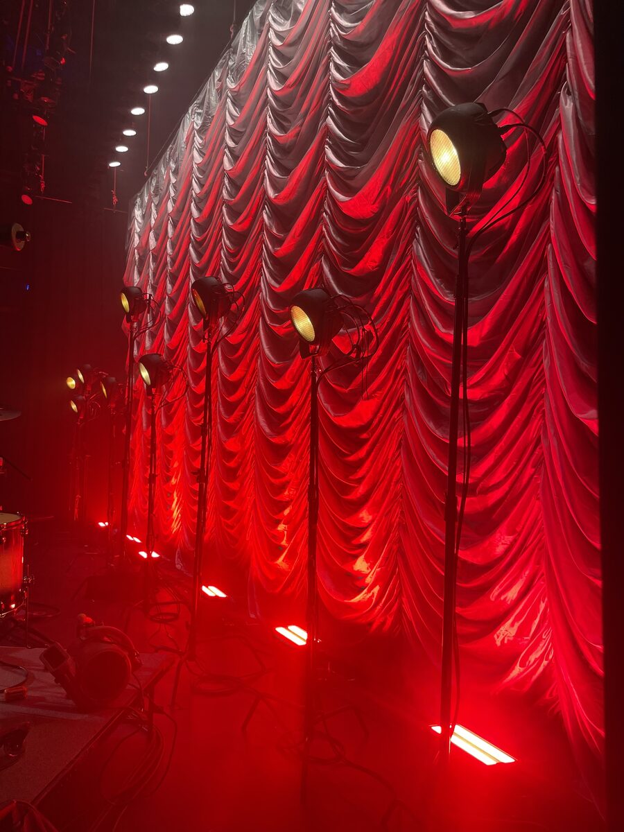 Silver Austrian swoop drape with dramatic red lighting